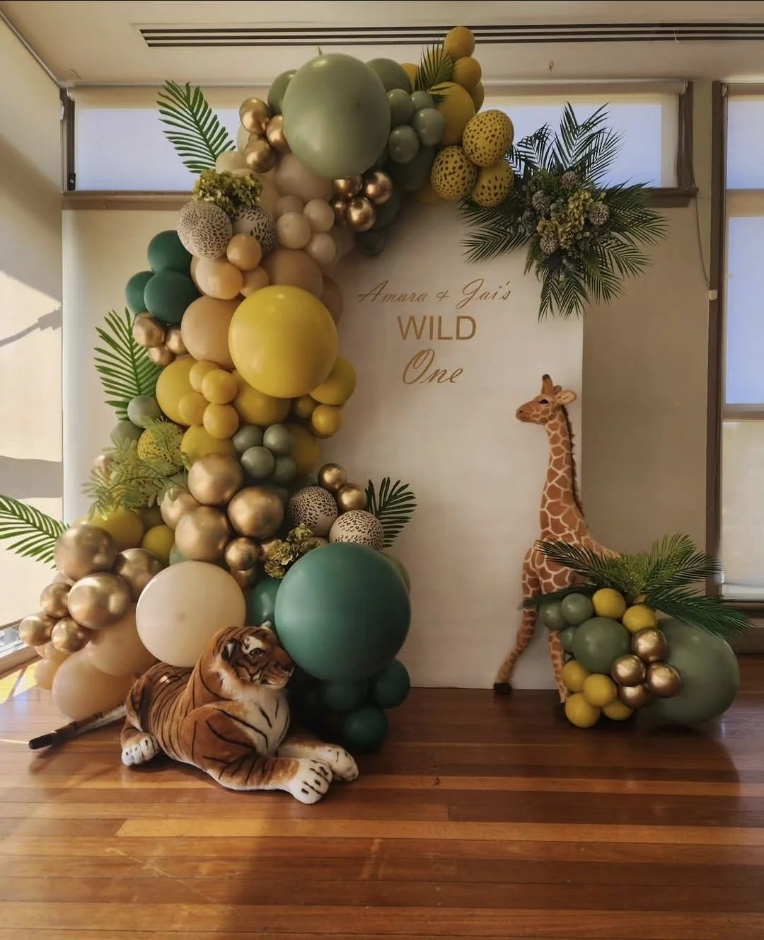 Organic-style green and gold balloon garland for a Wild One first birthday